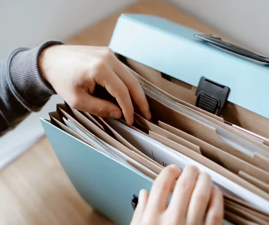 A person flipping through files in a folder